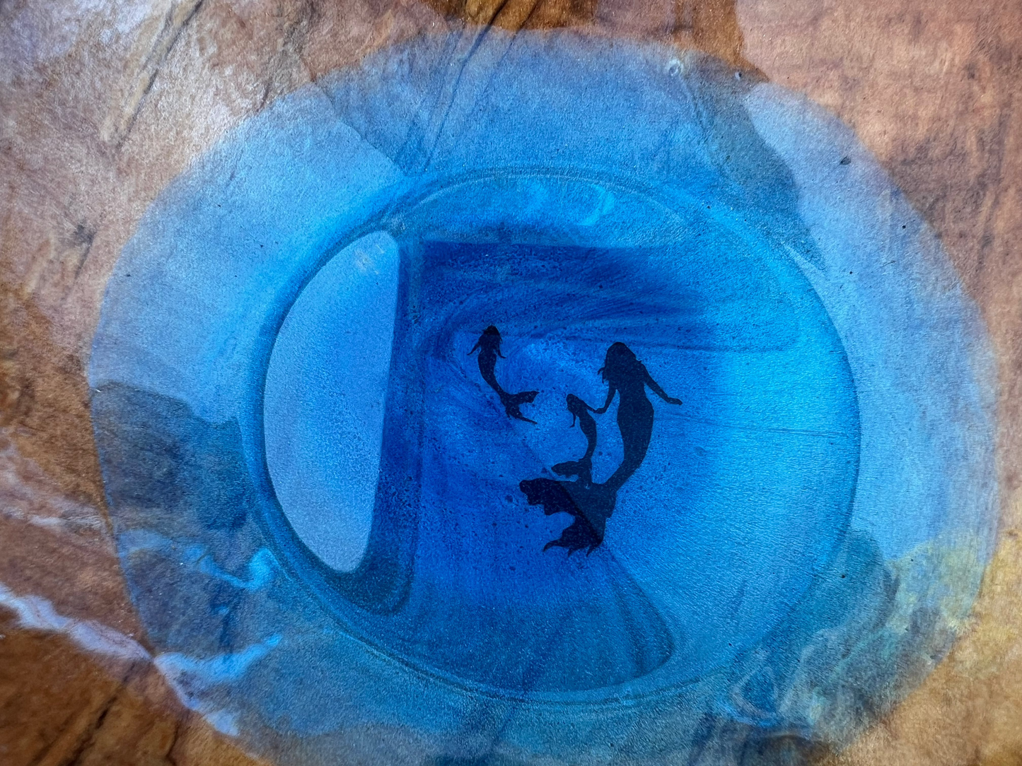 close up of inside of nut bowl with a momma and two baby mermaids