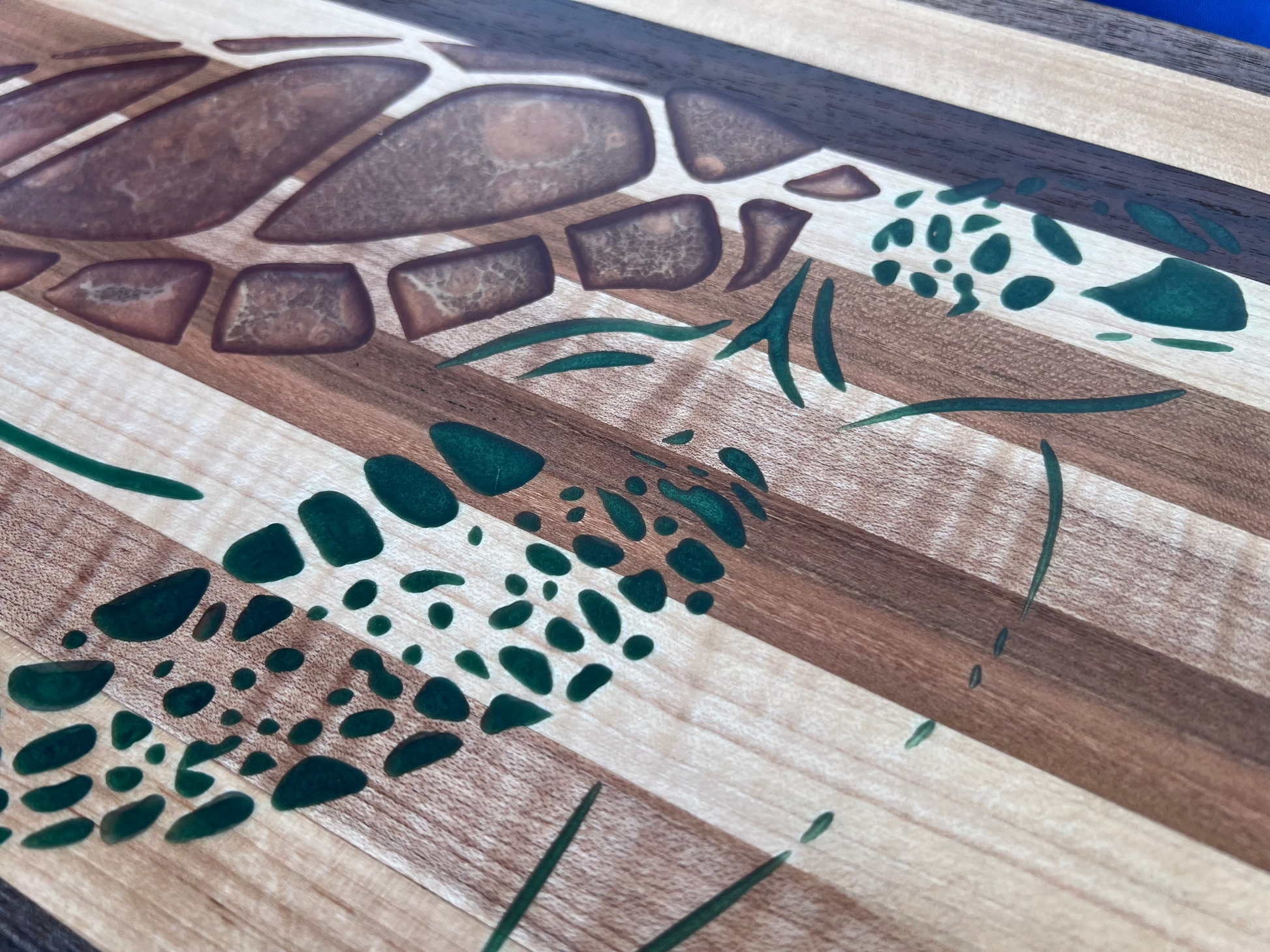 close up of sea turtle epoxy inlay on a hardwood charcuterie board