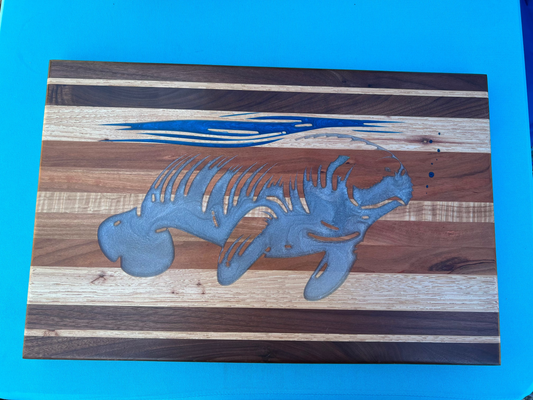 silver manatee epoxied on a hardwood charcuterie board