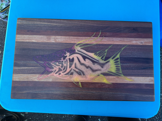 Wooden cutting board with a fish design on a blue surface